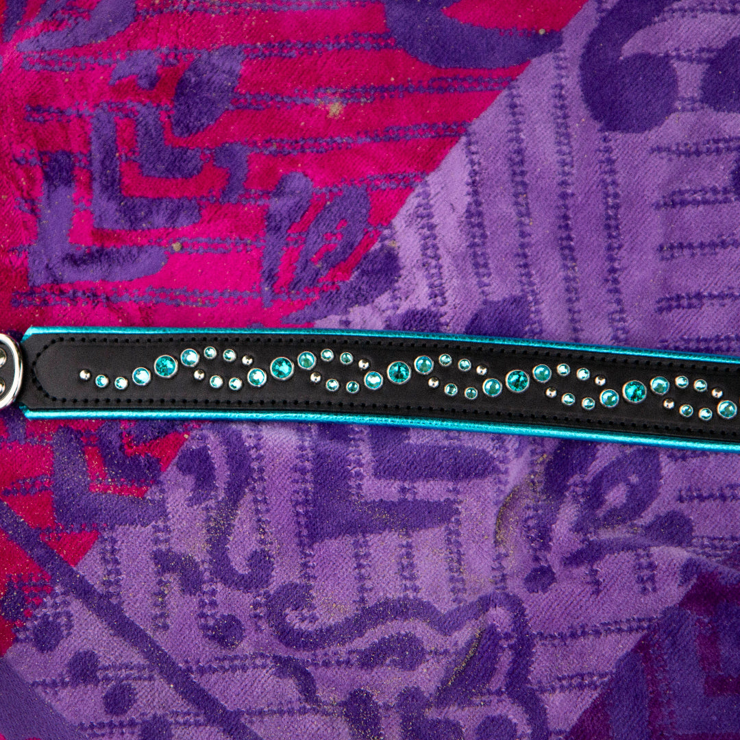Black leather dog collar with turquoise stones on a purple beach towel